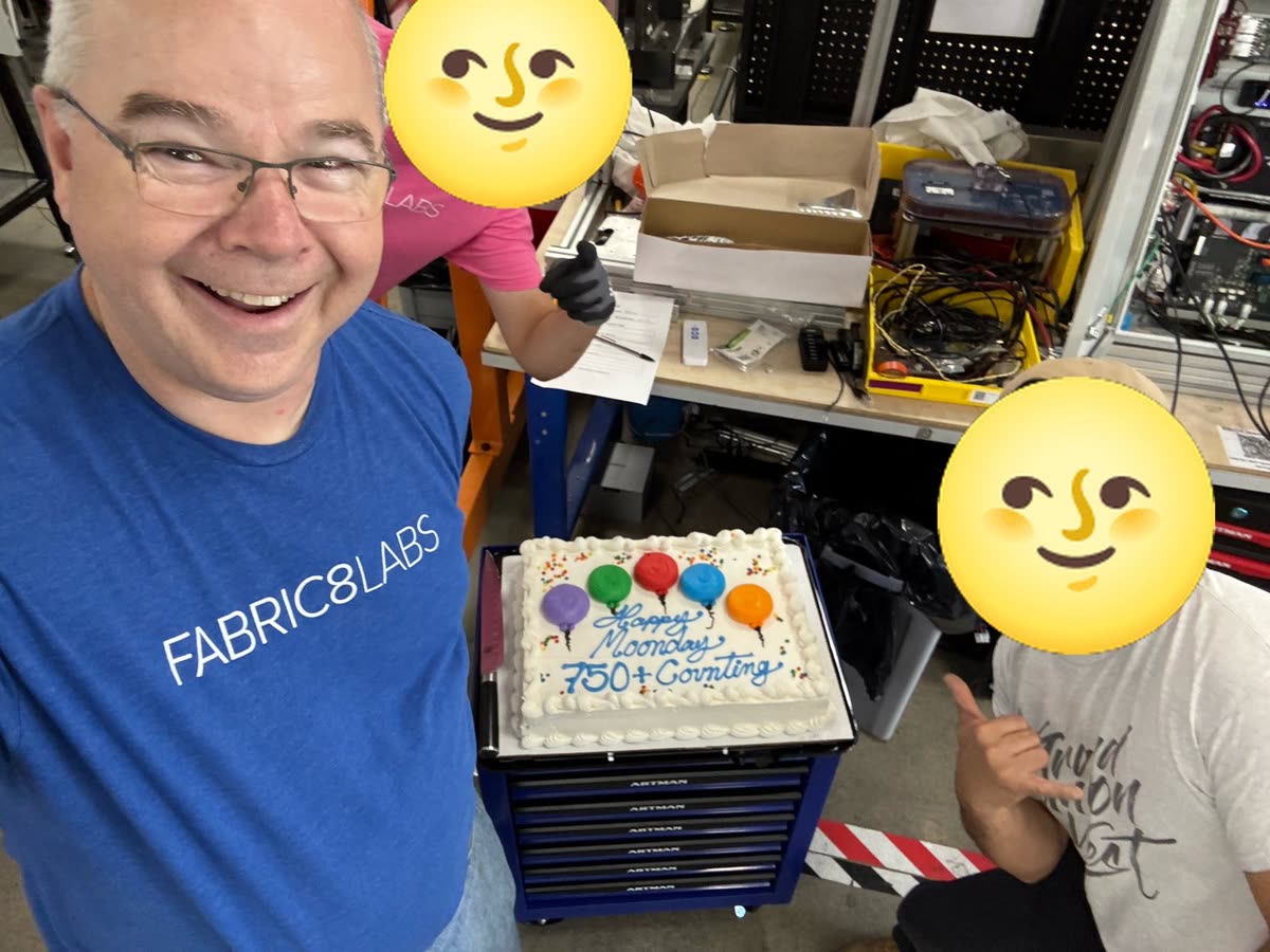 Ben smiling next to the Moonday cake at work